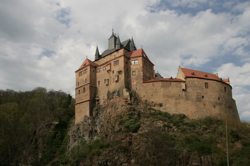Ansicht der Burg Kriebstein mit steilen Mauern hoch über der Zschopau von der anderen Seite des Flusses aus