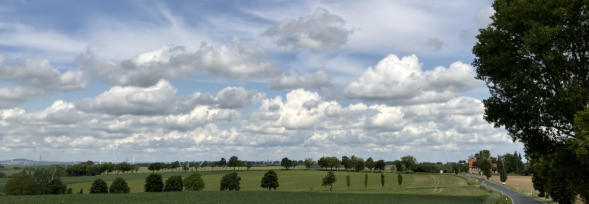 Wolken der Gattung Cumulus, links im Hintergrund der Collm